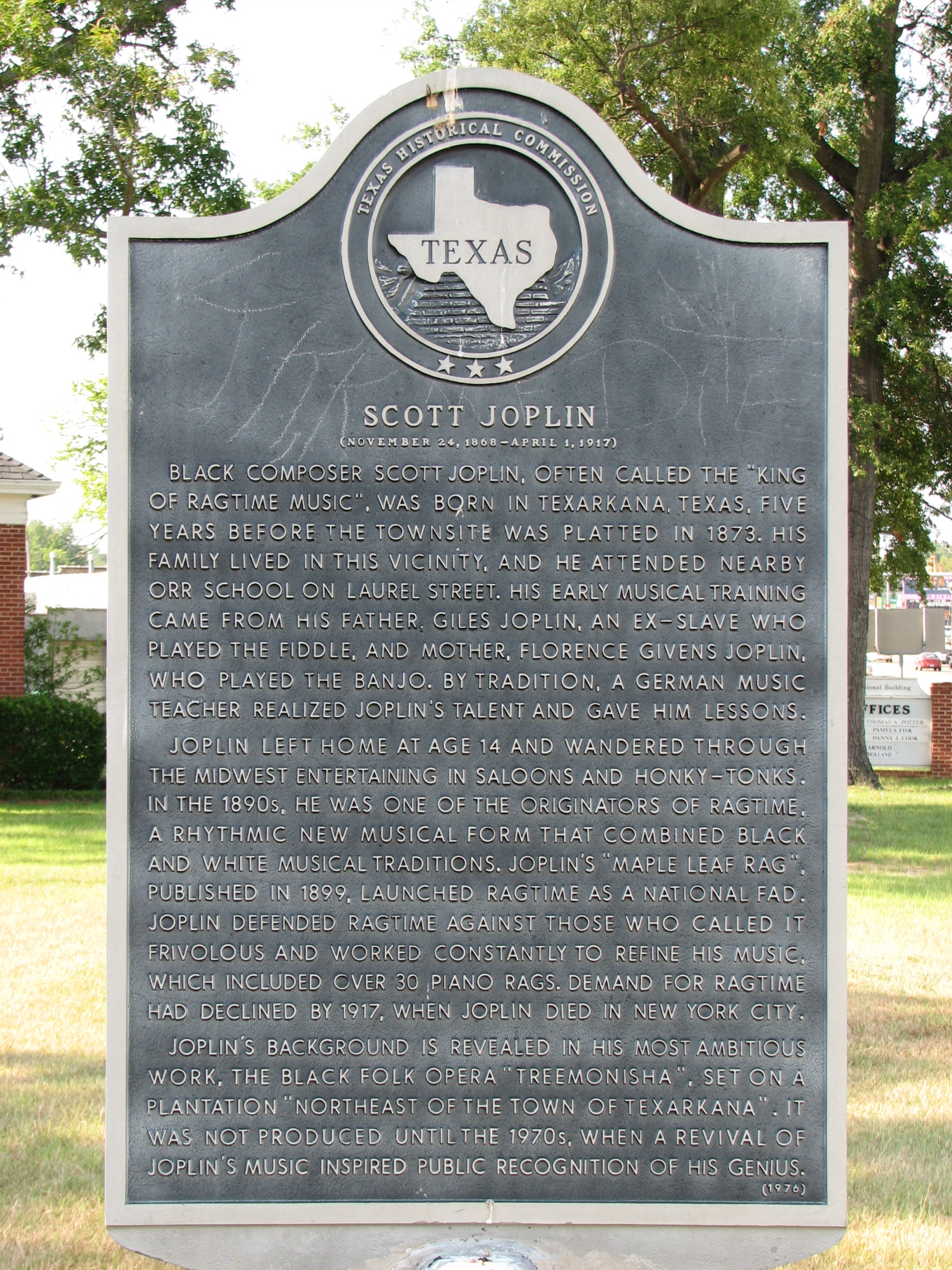 Texas historical marker for Scott Joplin in Texarkana. The sign provides a brief biography. Racist vandalism (chalk KKK marking) mars the sign.
