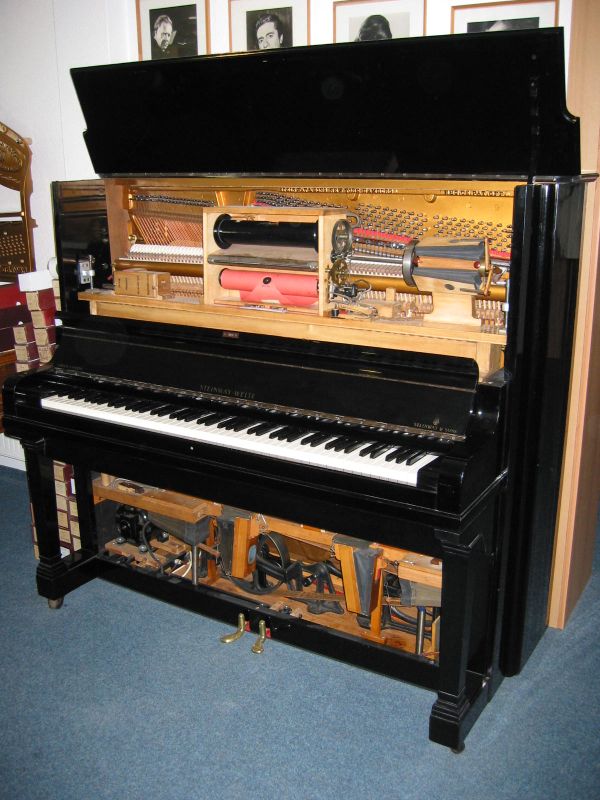Reproducing piano, used for recording piano rolls. The picture shows the piano opened up to reveal its recording roll as well as anatomy--its hammers, the roll itself, and the pedal mechanism.
