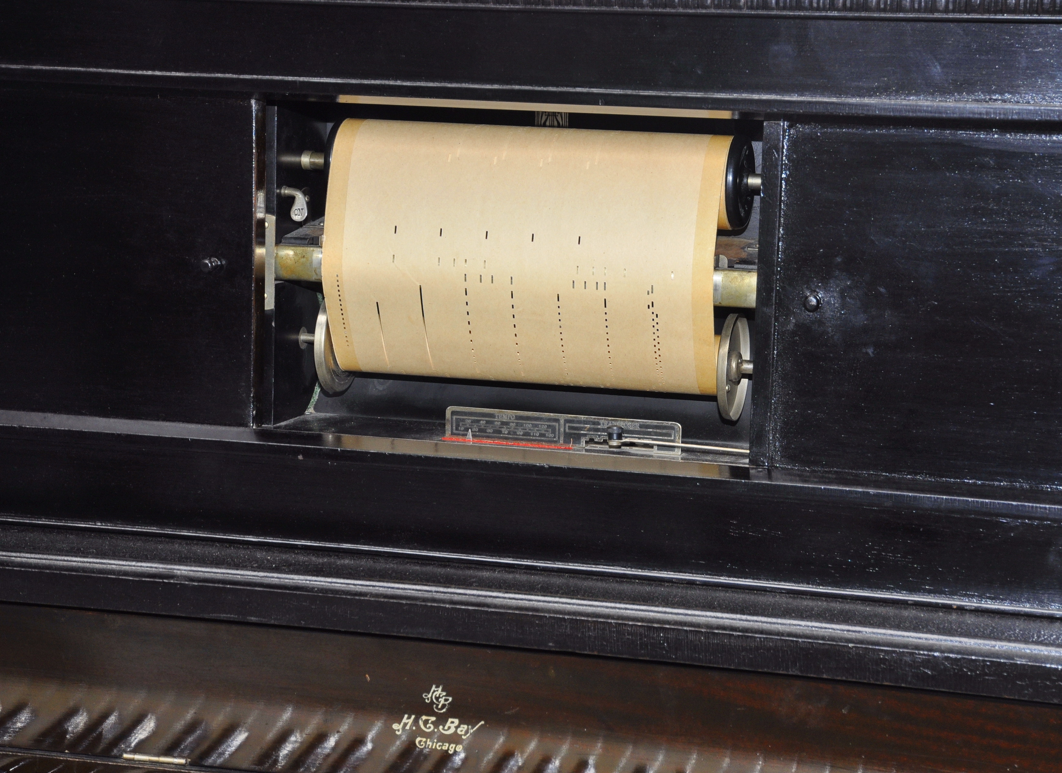 Close-up of a roll in a player piano. The roll consists of punctures, once recorded by a piano player.