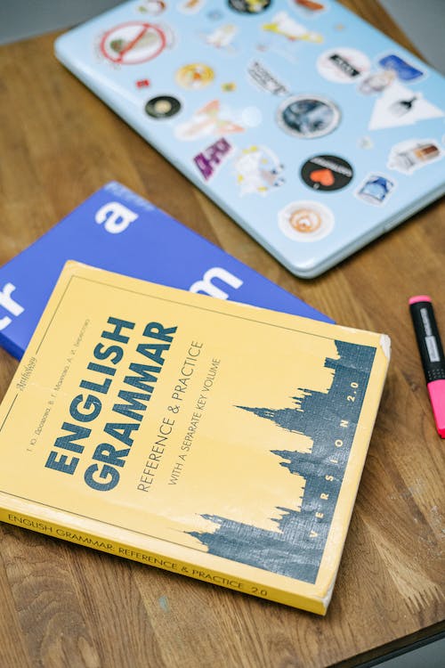 Laptop and Books on Brown Wooden Table